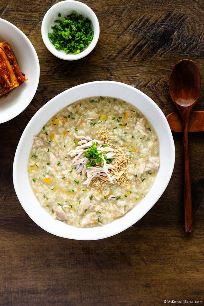 Homemade dakjuk served warm in a bowl with chicken and green onion garnishes