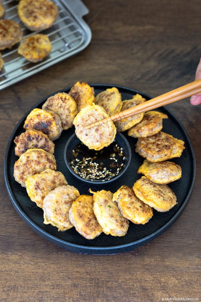 A donggeurangttaeng patty held with chopsticks.