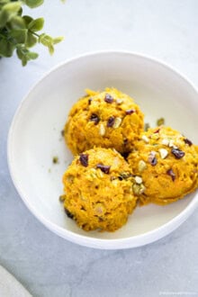 Korean Pumpkin Salad (Creamy & Sweet) Three scoops of creamy Korean pumpkin salad with chopped nuts and dried berries, served in a white bowl.